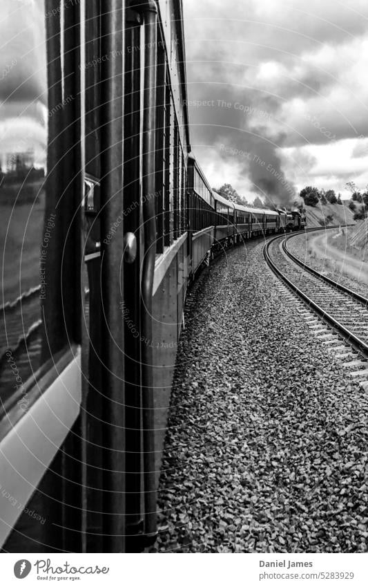 Dampfzug beim Durchfahren einer Kurve. Zug Verdunstung Rauch alt historisch altehrwürdig Schwarzweißfoto Eisenbahn Motor Dampflokomotive Schienenverkehr
