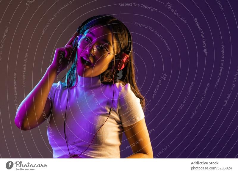Junge Frau trägt Kopfhörer beim Musikhören zuhören selbstbewusst jung Apparatur meloman modern Gesang Melodie cool Individualität pulsierend tausendjährig