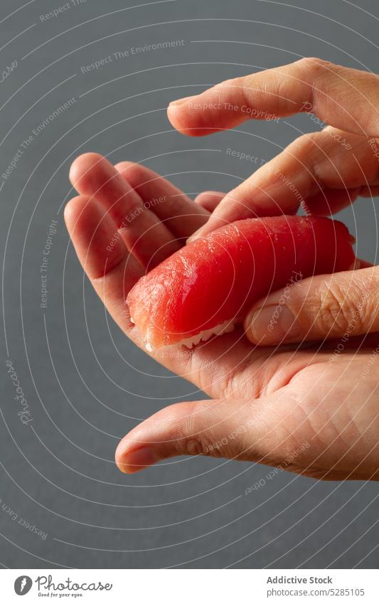 Crop-Hände machen Sashimi-Sushi Person Hand vorbereiten Koch Asiatische Küche Essstäbchen Orientalisch Lebensmittel Tradition Lachs Fisch handgefertigt Kultur