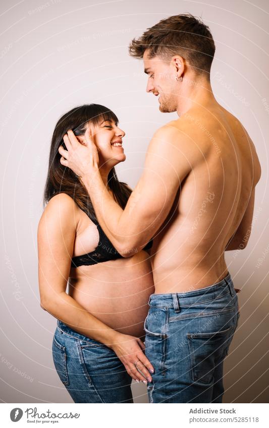 Glückliches Paar, das ein Baby erwartet, umarmt sich im Studio schwanger Haare berühren Umarmen warten Studioaufnahme Liebe Pflege erwarten Partnerschaft