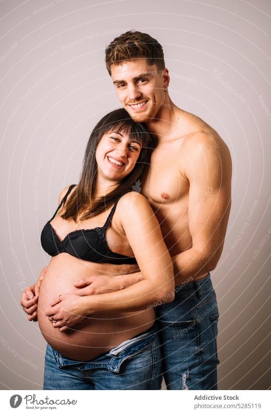 Mann umarmt schwangere Frau mit nacktem Bauch Paar Umarmung Bauch anfassen Umarmen warten Liebe Pflege erwarten unverhüllt friedlich jung Harmonie sanft