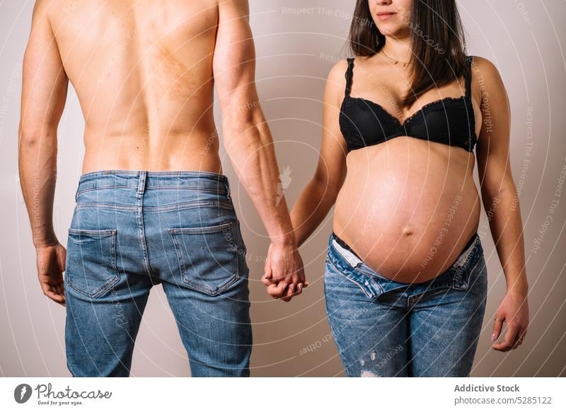Schwangere Frau hält Hände mit Mann Paar Ehemann schwanger Händchenhalten Ehefrau ohne Hemd Dessous Schwangerschaft Liebe mütterlich Hand Partnerschaft Bauch