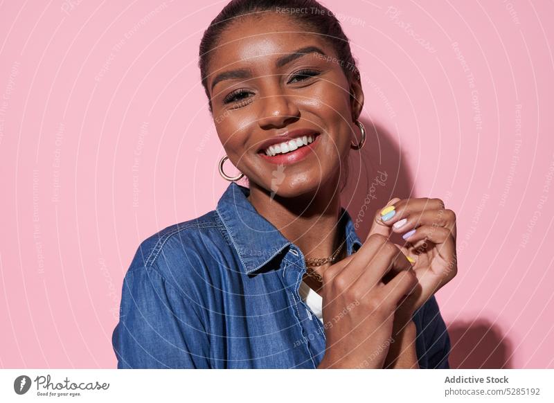 Glückliche schwarze Frau lächelt und schaut in die Kamera Lächeln Model heiter positiv Optimist Freude jung ethnisch Afroamerikaner Stil Porträt froh lebhaft
