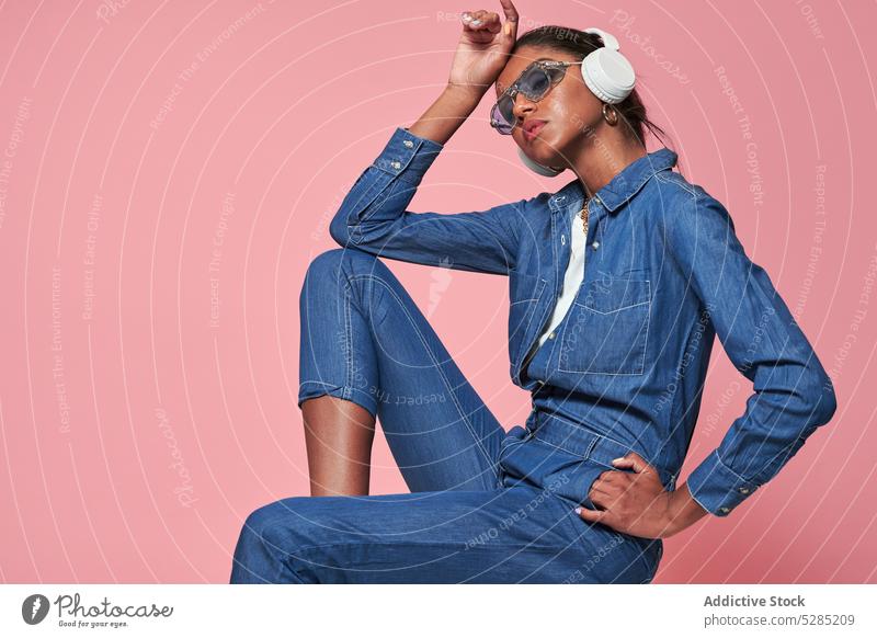 Stilvolle schwarze Frau mit Kopfhörern und Sonnenbrille zuhören Musik Model trendy Jeansstoff Afroamerikaner ethnisch jung modern Outfit Gerät Apparatur Gesang