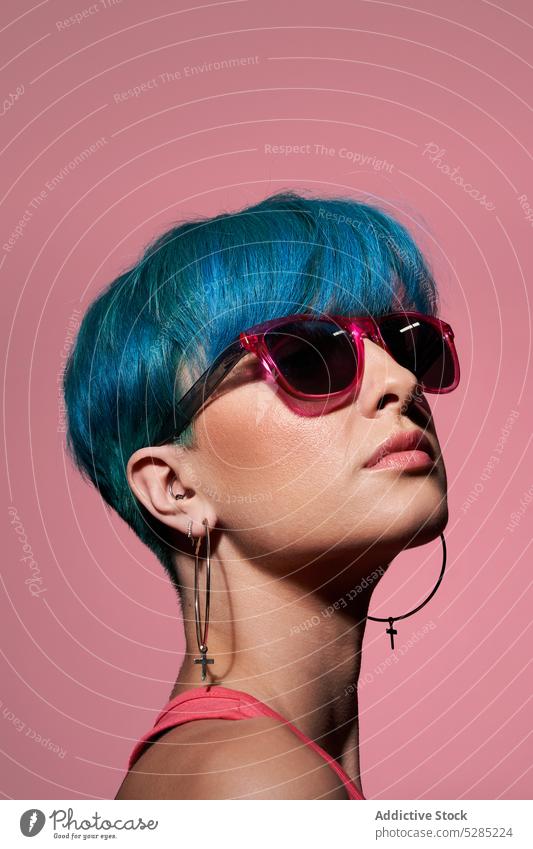 Stilvolle junge Frau mit blauem Haar Model Studioaufnahme Sonnenbrille blaue Haare gefärbtes Haar Individualität Persönlichkeit emotionslos Top stehen hell