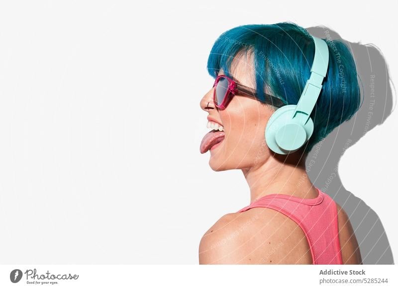 Coole Frau mit Kopfhörern streckt die Zunge heraus ausspannen gestikulieren zuhören Musik unterhalten aktiv cool Spaß Freude expressiv jung Klang Energie