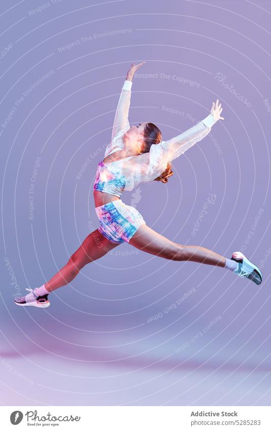 Energetische Frau springt im Studio springen laufen Bein angehoben Training schnell Aktivität angehobene Arme aktiv Gesunder Lebensstil Studioaufnahme