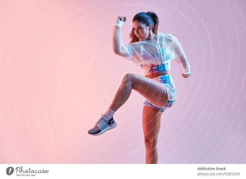 Stilvolle Sportlerin springt auf rosa Hintergrund Athlet springen aktiv Fitness Sportbekleidung Sportkleidung Energie passen farbenfroh Studioaufnahme jung Frau