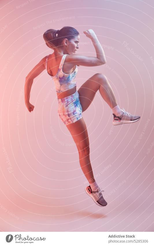 Stilvolle Sportlerin springt auf rosa Hintergrund Athlet springen aktiv Fitness Sportbekleidung Sportkleidung Energie passen farbenfroh Studioaufnahme jung Frau