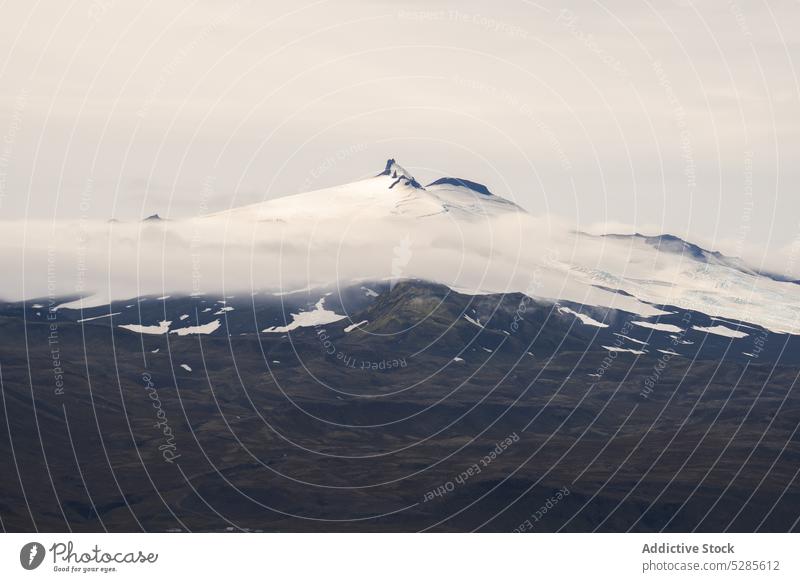 Verschneiter Gipfel eines Berges in Wolken Berge u. Gebirge Schnee Landschaft bedeckt Nebel Cloud Felsen Natur malerisch wolkig majestätisch Island Kamm Ambitus