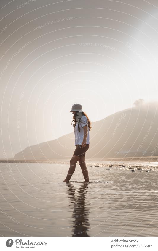 Frau geht im Meerwasser in der Nähe des Berges Tourist Spaziergang MEER Ufer Strand Sommer Berge u. Gebirge Urlaub Natur Küste Wasser Spanien Asturien Hut Sonne
