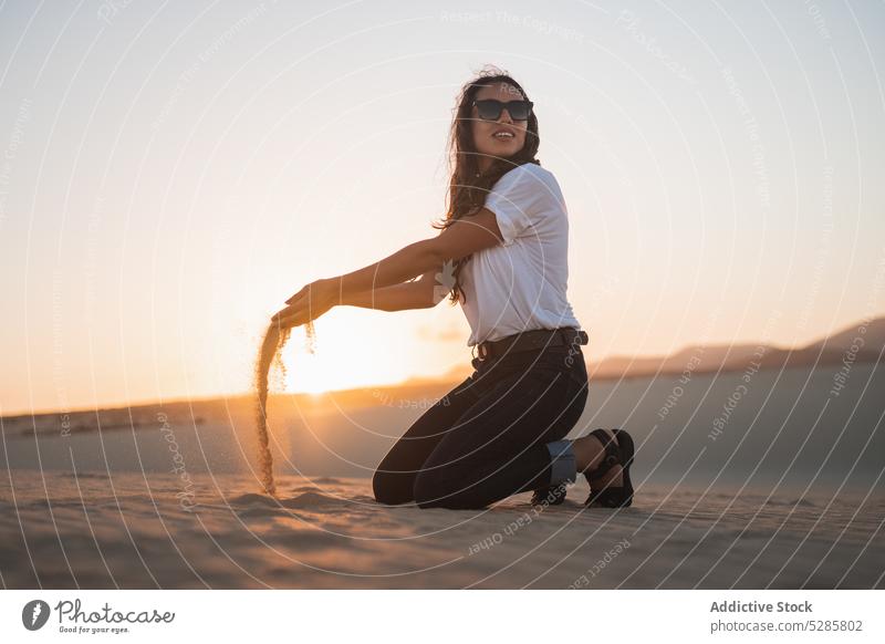 Glückliche Frau spielt mit Sand Strand spielen Lächeln Sonnenuntergang heiter Sommer MEER Küste Urlaub Sonnenbrille lässig sich[Akk] entspannen Bali ruhen Abend