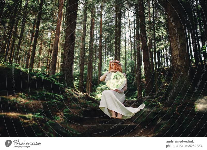 schöne rothaarige Braut im weißen Kleid mit einem Spiegel im grünen Wald Frau Glück Fröhlichkeit Mädchen Natur im Freien Menschen Porträt Lächeln Schönheit