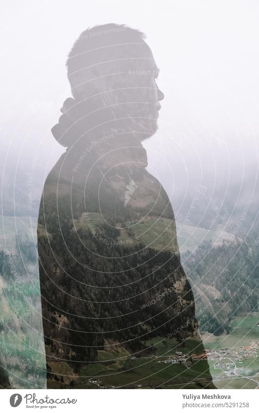 Double exposure  male silhouette in a hood portrait close-up on mountains background.Mountain landscape and silhouette of a man.Human and nature inspiration