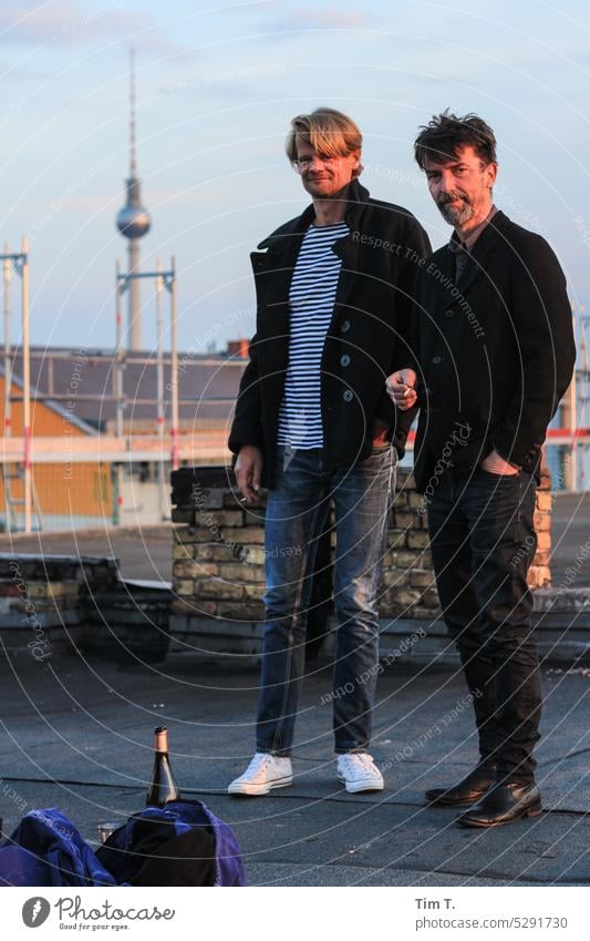 Zwei Männer auf dem Dach . Im Hintergrund der Fernsehturm im Vordergrund eine Flasche Wein Berlin Prenzlauer Berg Mann zwei Stadtzentrum Hauptstadt