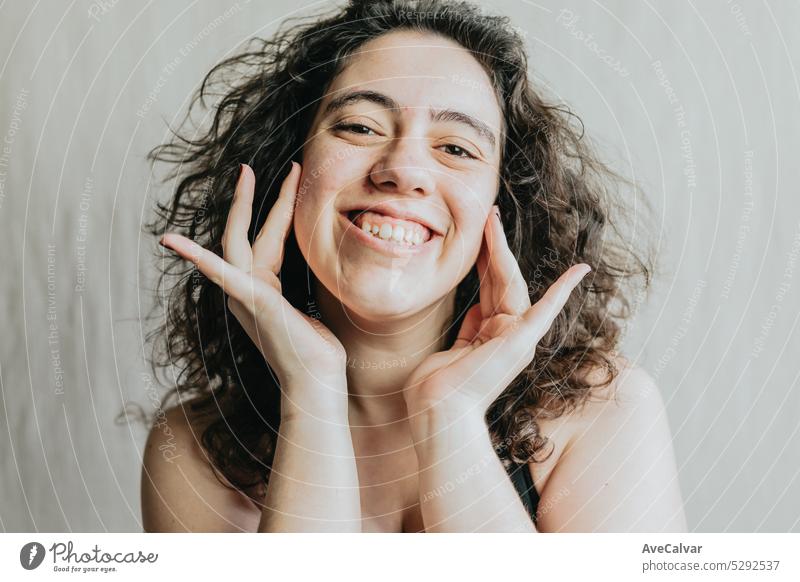 Porträt einer fröhlichen Frau, die mit ihren Händen auf dem Gesicht ihr Glück ausdrückt Lächeln Freude Fröhlichkeit heiter Positivität Gefühle Ausdruck