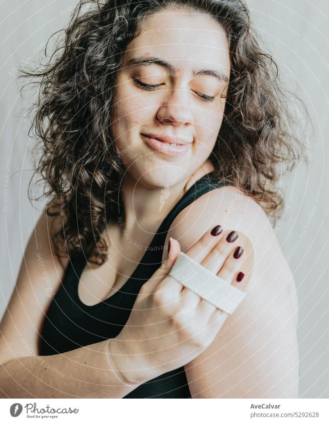 Frau bei einer Massage mit einem hölzernen Handmassagegerät. Persönliche Hygiene und Körperpflege, Morgen- und Abendrituale. Entspannte Anti-Cellulite-Behandlung.