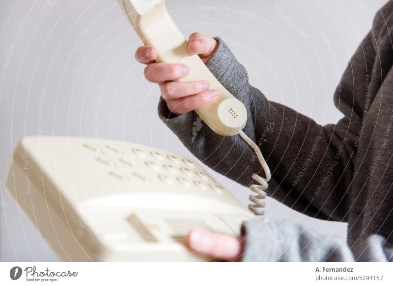 Frau, die den Hörer eines alten Retro-Telefons in der Hand hält. Konzept des Wandels der Kommunikationsmittel altes Telefon Telefonanschluss Telefonnummer