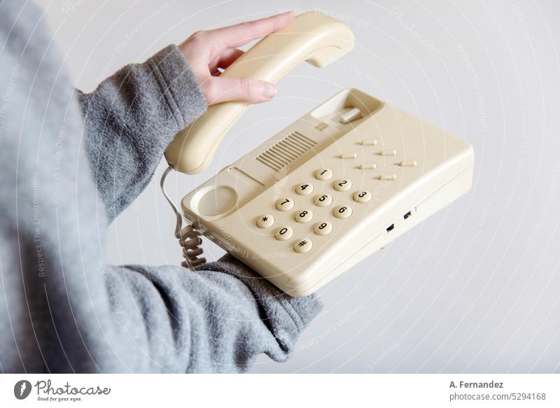 Frau, die an ein altes Retro-Telefongerät geht. Konzept der Veränderungen in der Kommunikation altes Telefon Telefonanschluss Telefonnummer Telefonkabel
