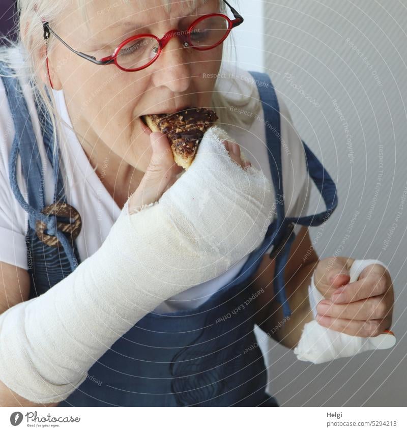 MainFux-UT | auch mit Gipsarm klappt es mit der Nussecke Frau Mensch Seniorin Verletzung Verband essen Genuss genießen Einschränkung Porträt Essen Lebensmittel