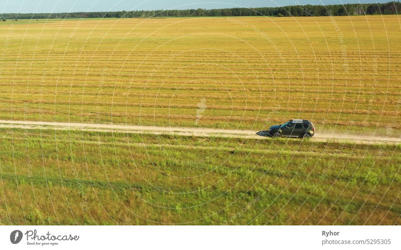 Gomel, Weißrussland - Juli 6, 2021: Luftaufnahme von Renault Duster Auto SUV auf dem Lande Straße durch Sommer grünes Feld. Landwirtschaftliche Land Felder Ländliche Landschaft. Auto fahren in Bewegung