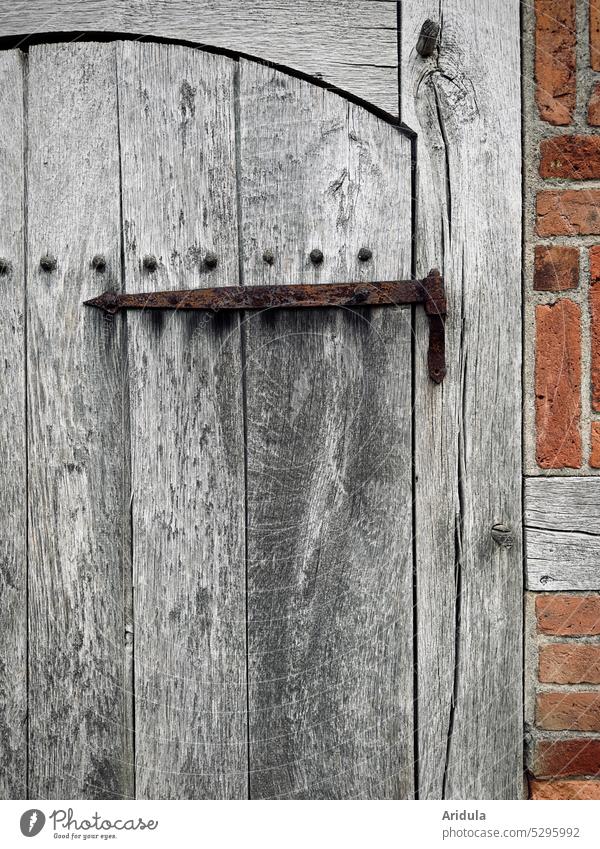 Teil einer alten vergrauten Holztür mit verrosteter Türangel Rost Fachwerk Backstein Mauer Haus Mittelalter Architektur Denkmalschutz Gebäude Bauwerk