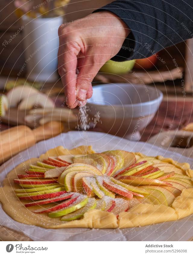 Kropfenkoch bestreut Apfelkuchen mit Zucker Person Hand bestäuben Koch Galette Pasteten selbstgemacht Mürbeteig vorbereiten Teigwaren ungebacken Bestandteil