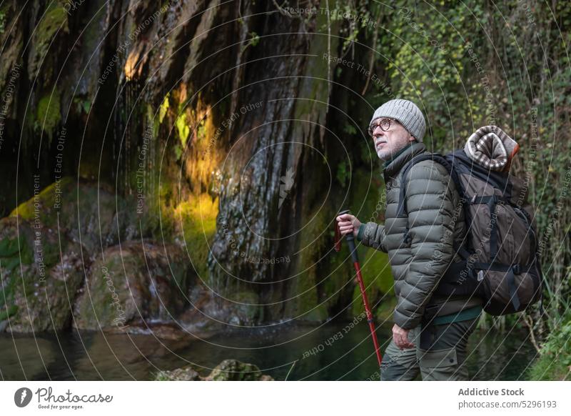 Reisende bewundern malerische Aussicht Mann Wald Wanderer Trekking Trekkingstöcke Reisender Wasserfall Fluss Natur erkunden Ufer männlich Rucksack Abenteuer