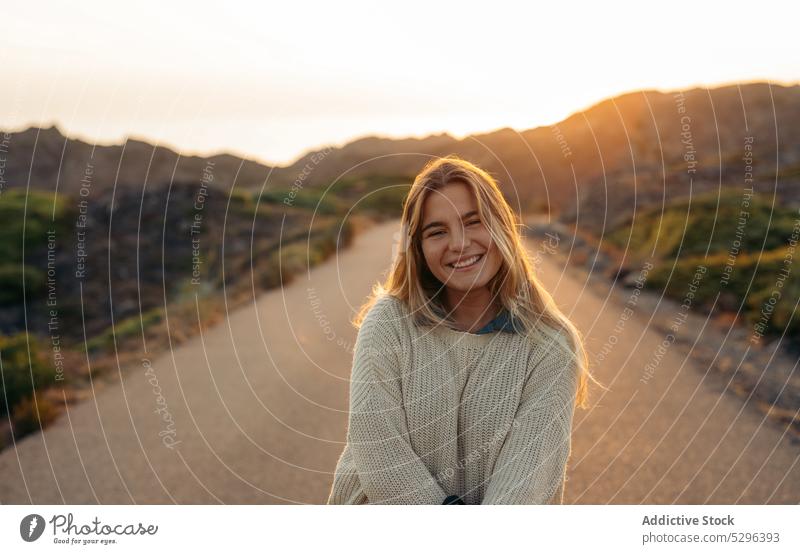 Lächelnde Frau vor Bergen bei Sonnenuntergang Straße Sommer Berge u. Gebirge Reisender malerisch Freizeit Ausflug Glück reisen Freiheit genießen idyllisch