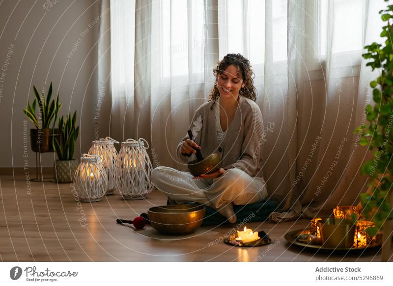 Glückliche junge Frau spielt Klangschale während der Meditation Gesangsbogen meditieren Lächeln Erholung Aromatherapie spielen positiv Sprit Yoga