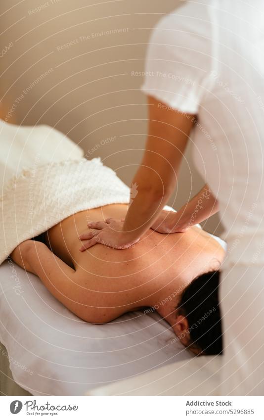 Anonymer Therapeut massiert Rücken und Nacken einer Kundin Frauen Massage Akupunktur Spa Verfahren Wohlbefinden Masseurin Salon Wellness Lügen Spezialist Klient