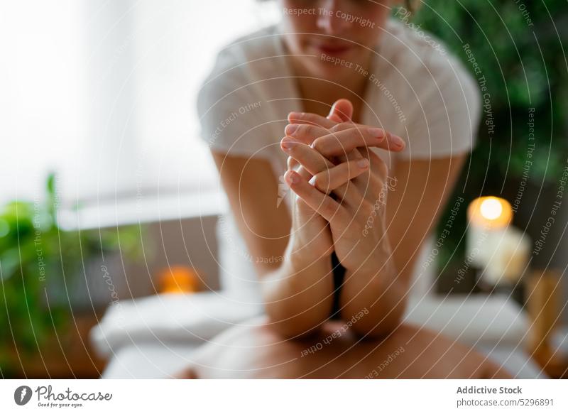 Fokussierte hispanische Masseurin bei der Akupunkturmassage einer weiblichen Kundin Frauen Massage Gesundheitswesen Wiederherstellung Konzentration Klient