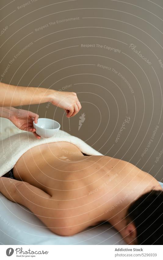 Masseurin trägt während der Massage Körperöl auf den Rücken einer Kundin auf Frauen Erdöl Therapie sich[Akk] entspannen Spa eingießen Wellness Körperpflege