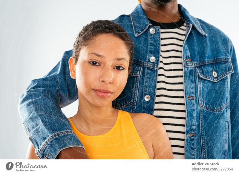 Ethnisches Paar umarmt auf weißem Hintergrund Freund Freundin Partnerschaft Umarmen Umarmung Jeanshose Streetstyle Stil Jeansstoff Afroamerikaner ethnisch