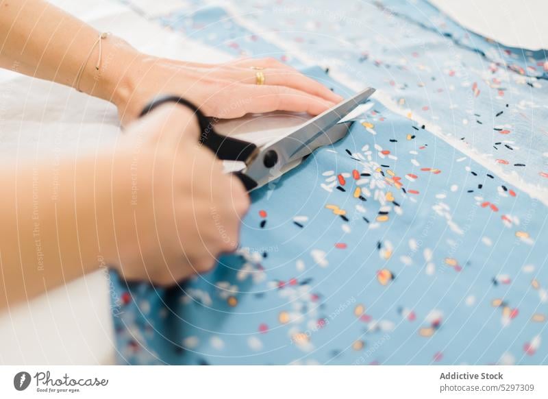 Unbekannter Designer schneidet Stoff im Atelier zu Damenschneiderin Gewebe geschnitten Schneider Schere Muster Werkstatt Kleinunternehmen Arbeit Textil Material