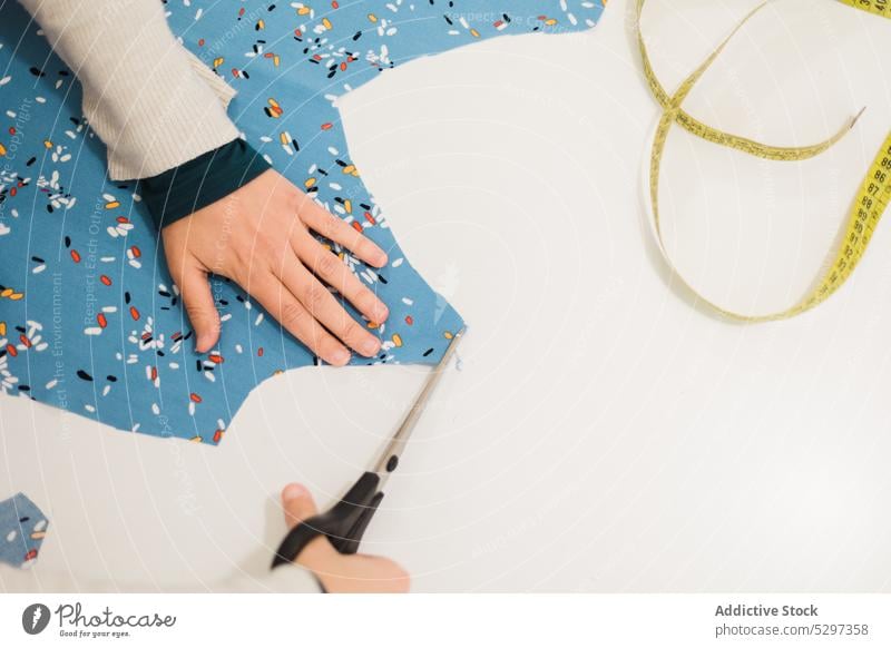 Gesichtsloser Designer schneidet ein Stück Stoff im Atelier zu Frau Gewebe geschnitten Schneider Damenschneiderin Schere kreativ Textil Kleinunternehmen Arbeit
