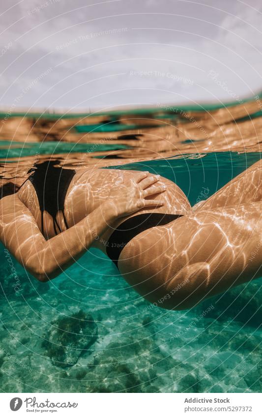 Unerkennbare schwangere Frau beim Tauchen im Meer schwimmen unter Wasser Fisch Sinkflug unterseeisch Urlaub MEER Bikini durchsichtig blau Feiertag reffen