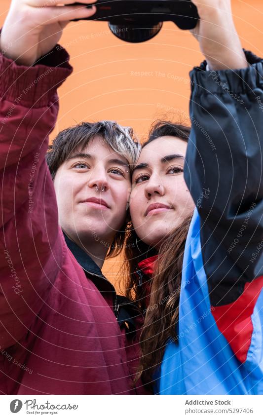 Junges lesbisches Paar nimmt Selfie auf Filmkamera Fotoapparat Gedächtnis fotografieren lgbt Liebe Partnerschaft positiv jung Homosexualität Freundin Fotografie