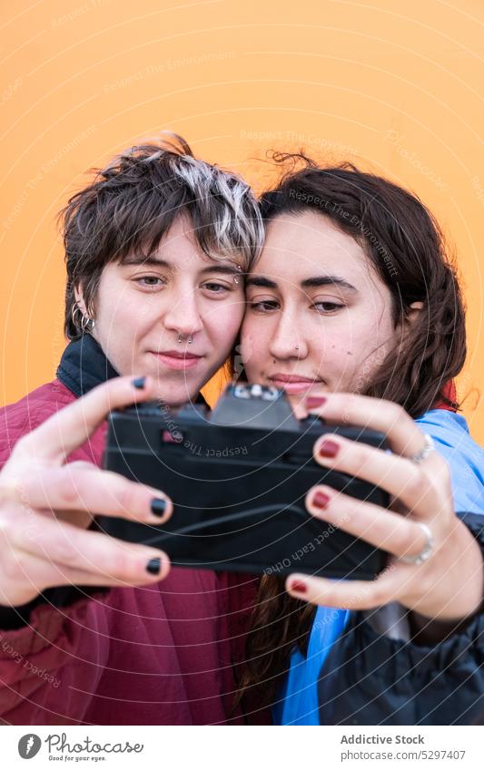 Junges lesbisches Paar nimmt Selfie auf Filmkamera Fotoapparat Gedächtnis fotografieren lgbt Liebe Partnerschaft positiv jung Homosexualität Freundin Fotografie
