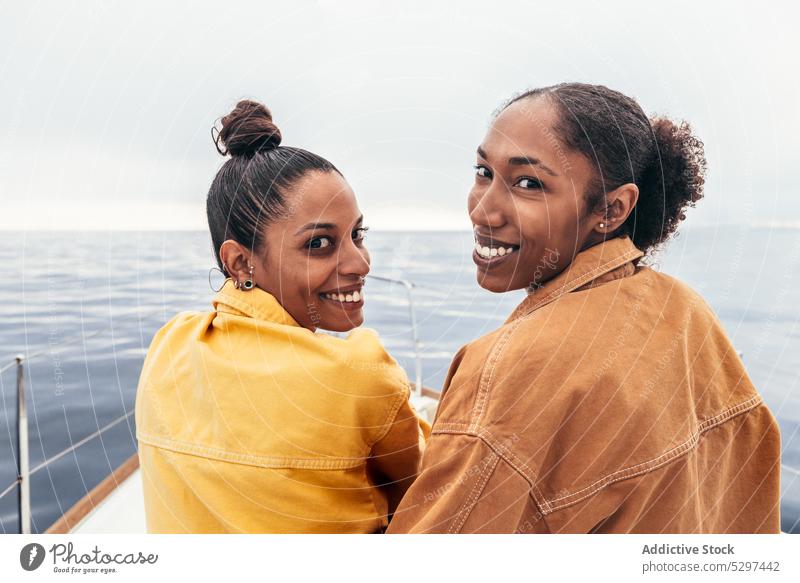 Fröhliche schwarze Frauen schauen in die Kamera gegen das Meer Jacht Lächeln MEER Strand Sommer ruhen Freund sich[Akk] entspannen Glück Zusammensein ethnisch