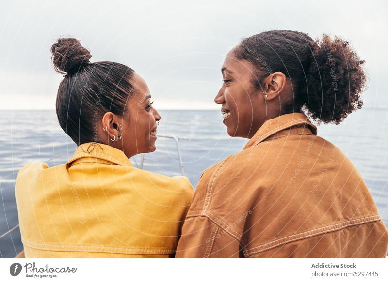 Fröhliche schwarze Frauen, die sich gegenseitig gegen das Meer ansehen Jacht Lächeln MEER Strand Sommer ruhen Freund sich[Akk] entspannen Glück Zusammensein
