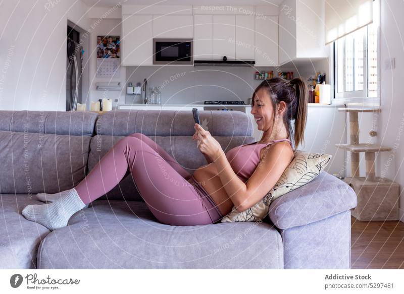 Konzentrierte schwangere Frau mit Tablette auf dem Sofa benutzend Browsen Schwangerschaft heimwärts ruhen Komfort Liege Apparatur Gerät Internet online