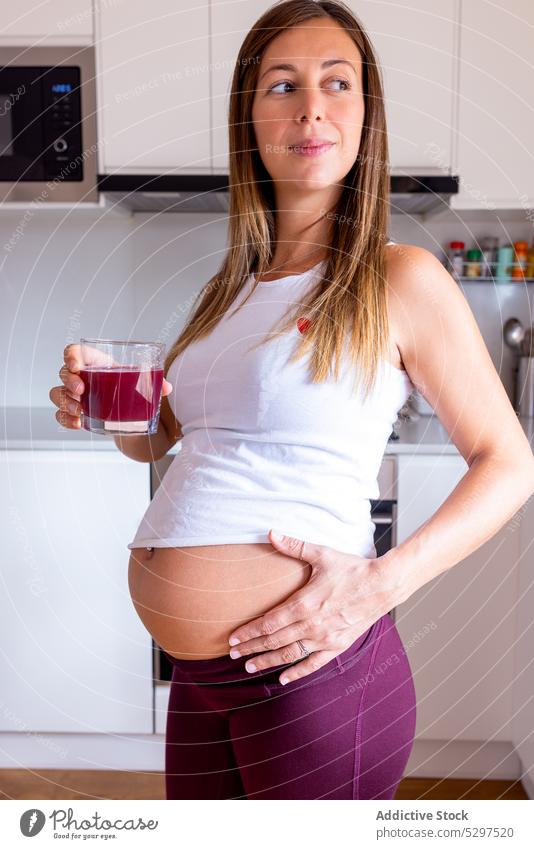 Schwangere Frau trinkt Saft in der Küche schwanger trinken Getränk erwarten Schwangerschaft heimwärts Bauch frisch Gesundheit Windstille Abfertigungsschalter