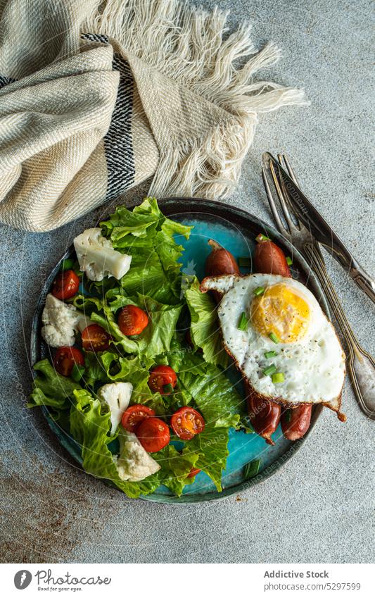 Mittagessen mit Salat und Würstchen Salatbeilage Frühstück Ei Lebensmittel Amerikaner Deutsch Hintergrund Käse Kirschtomate Beton Essen zubereiten Besteck Diät
