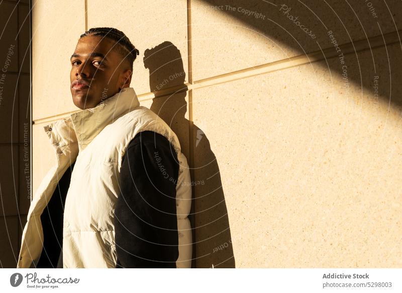 Stilvoller schwarzer Mann in trendigem Outfit auf der Straße stehend Großstadt trendy selbstbewusst urban Wand modern jung männlich Afroamerikaner ethnisch