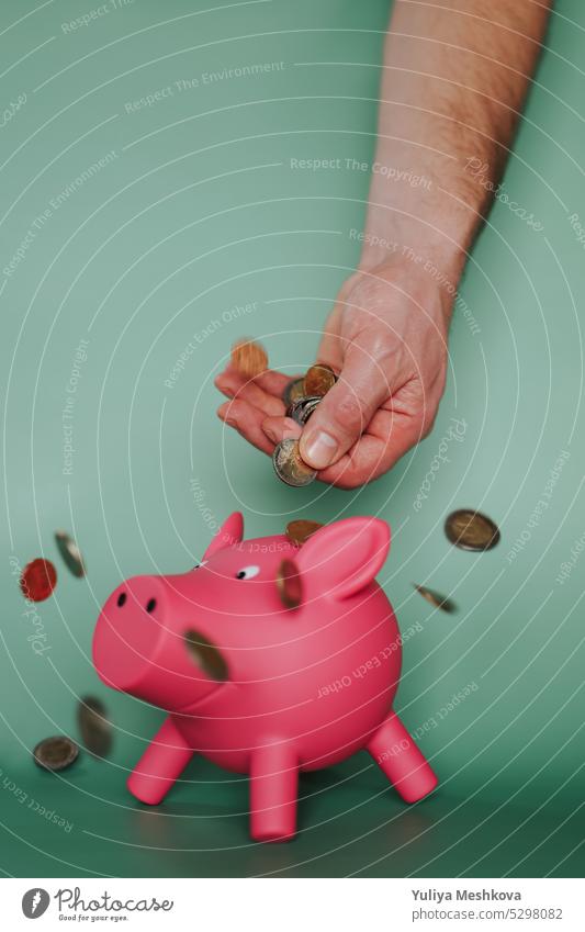 Sparschwein.Ersparnisse und Ausgaben in Europa.Einkommen und Ausgaben in der Eurozone. Schweinchen Bank Einsparungen Hand Konzept fallend Münzen