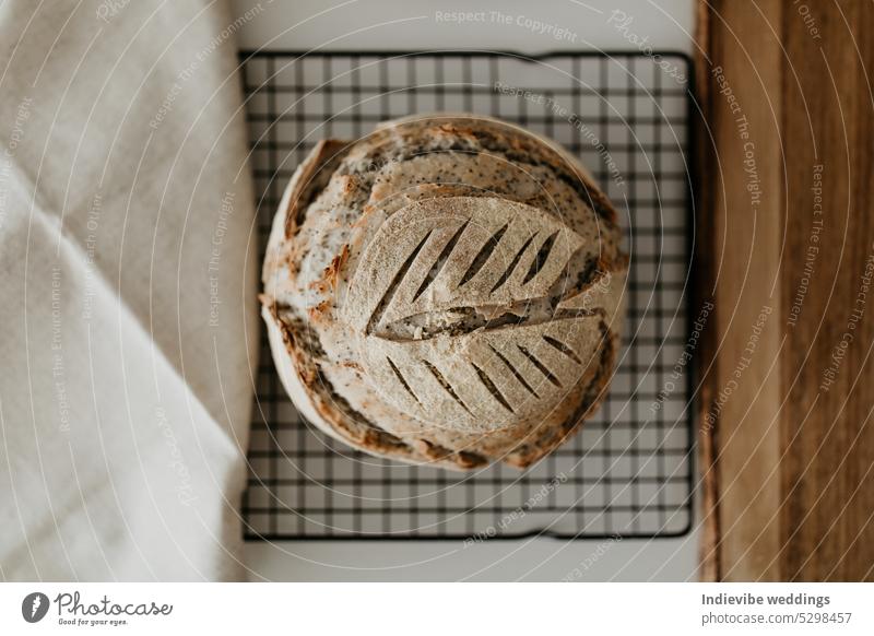 Sauerteigbrot. Selbstgebackenes Brot auf dem Kühlregal. Sanft verschwommener weißer Hintergrund. Gemütliche Wohnung lag mit hölzernen Schneidebrett und Leinen Serviette