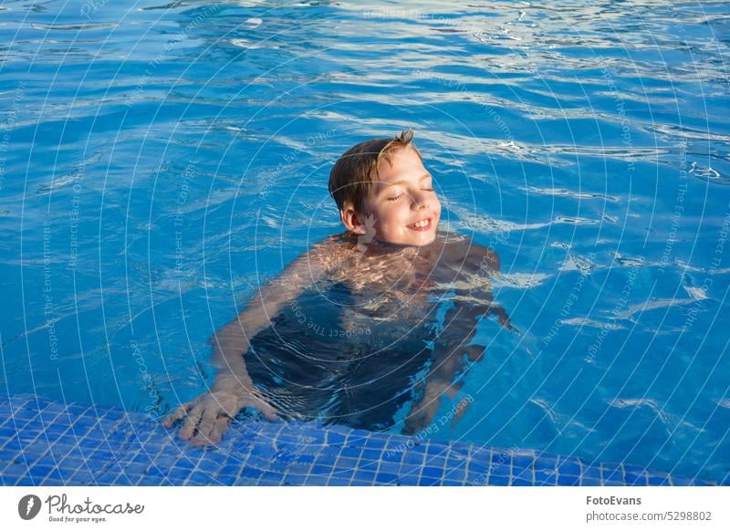 Ein Junge im Schwimmbad Lachen sonnig Textfreiraum Teenager Freude Wasser Tag Urlaub Bewegung aktiv Pool sportlich Sommer Sport Kind Gesundheit reisen
