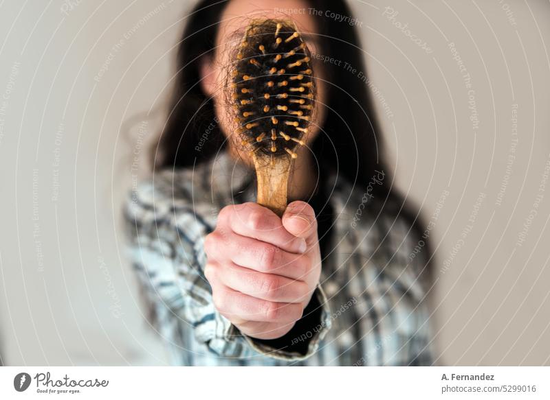 Frau zeigt der Kamera eine Haarbürste voll mit Haaren. Konzept des Haarausfalls. Kahlheit, weibliche Alopezie. Behaarung Haare & Frisuren Haare bürsten