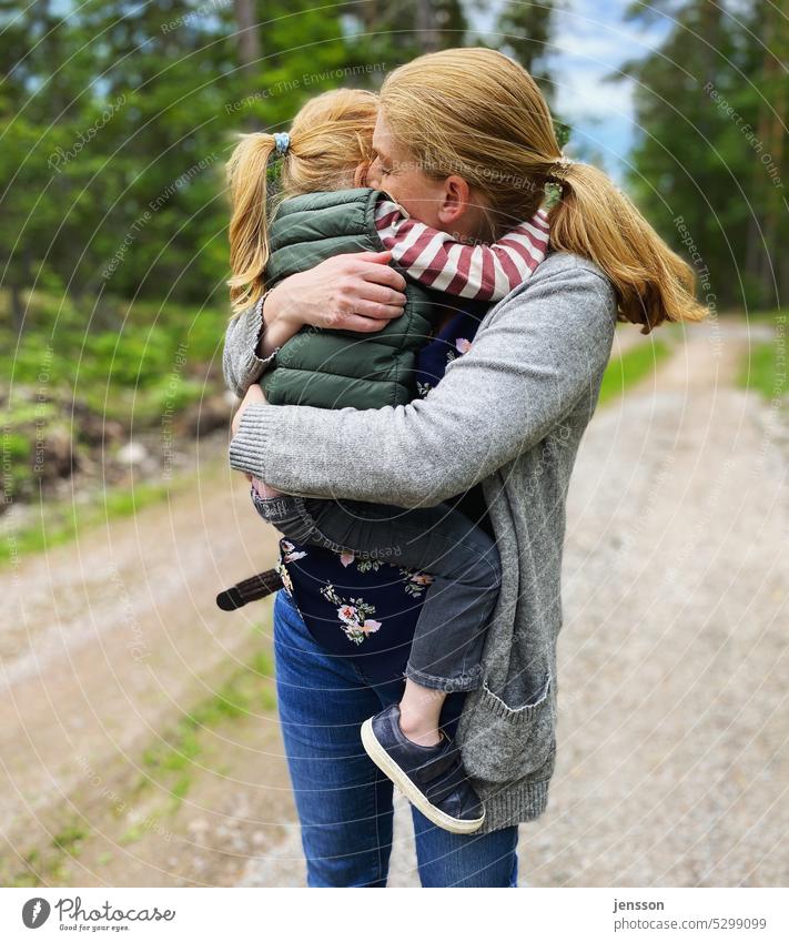 Eine Mutter kuschelt mit ihrer Tochter auf dem Arm innig vertraut Vertrauen Geborgenheit geborgen Mutter mit Kind Mutterliebe Muttergefühl Mutter und Tochter